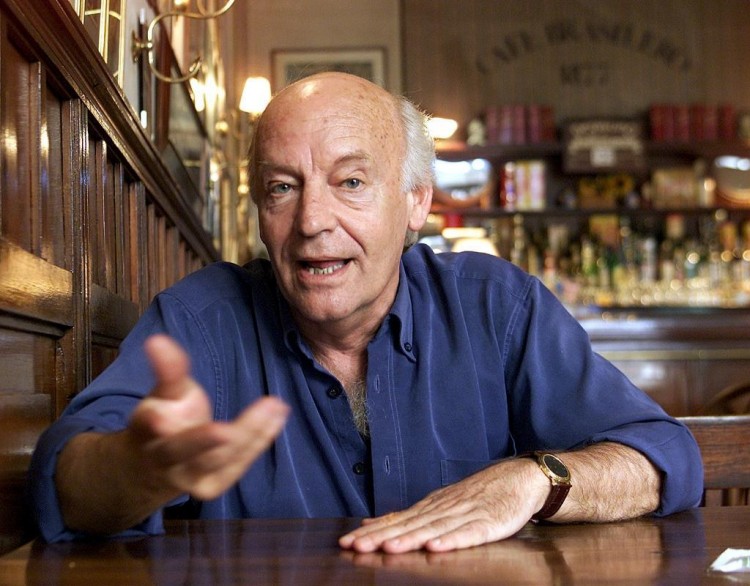 Uruguayan writer Eduardo Galeano gestures at his favorite pub "Cafe Brasilero" in Montevideo, in this October 25, 2002 file picture. Galeano, a Uruguayan journalist and author who was a leading light in Latin America's anti-capitalist movement, died after a battle with lung cancer on April 13, 2015, his publisher said. He was 74. REUTERS/Andres Stapff/Files